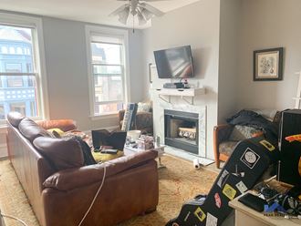 a living room with couches and a fireplace and a tv