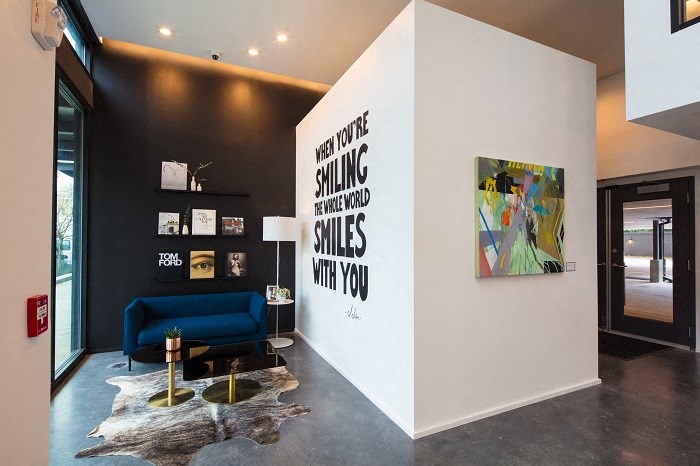 a living room with a blue couch and a wall with a painting on it