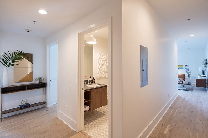 a view of a hallway with a bathroom and a mirror