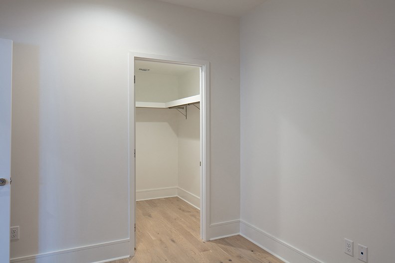 an empty closet in a room with white walls and wood floors