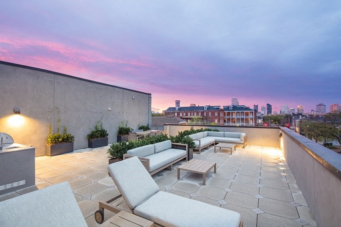 a rooftop terrace with couches and a view of the city