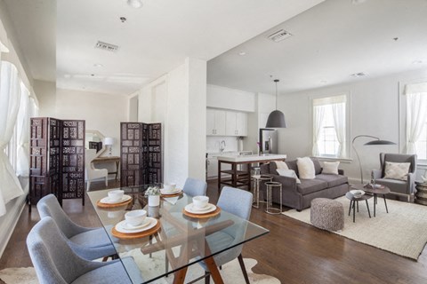 a living room and dining room with a glass table and chairs