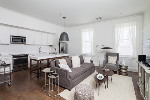 a living room with a couch and a kitchen with a table