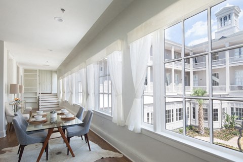 a dining room with large windows and a table and chairs
