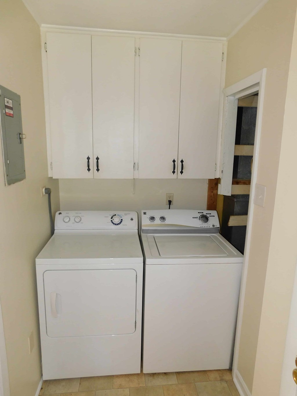 a washer and dryer in a room with white cabinets