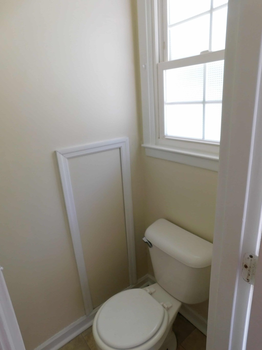 a small bathroom with a toilet and a window