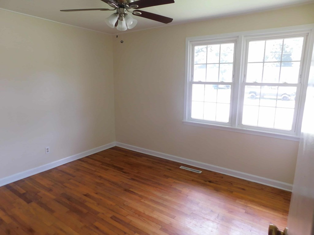 a room with a wood floor and a ceiling fan