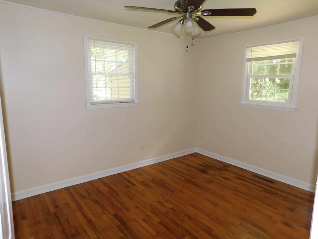 a room with a wooden floor and a ceiling fan