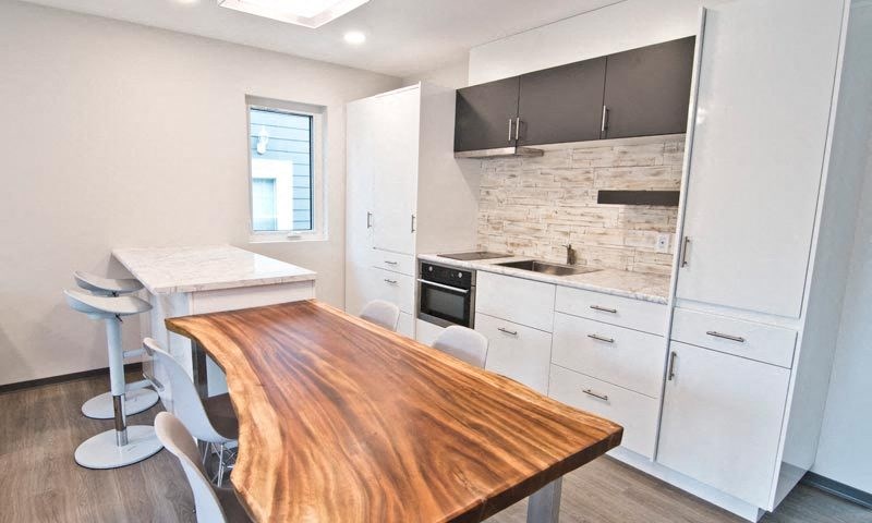 a kitchen with a wooden table and white cabinets