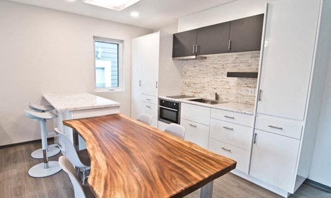 a kitchen with a wooden table and white cabinets
