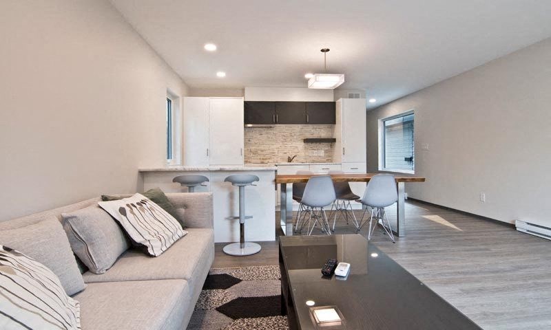 a living room and kitchen with a couch and a table