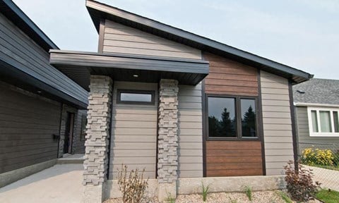 a house with a wood and stone facade and a wooden door