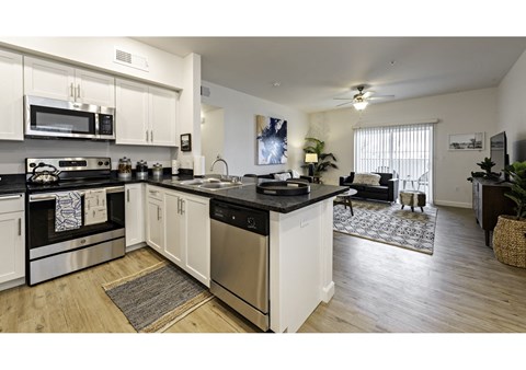 an open kitchen and living room with a counter top and appliances