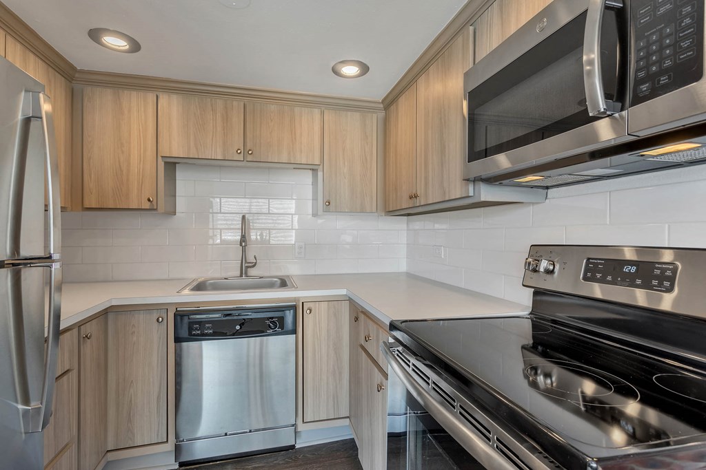 a kitchen with stainless steel appliances and wooden cabinets