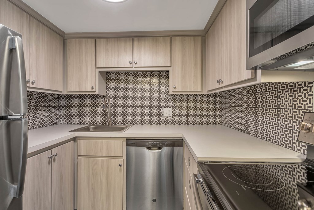 a kitchen with wooden cabinets and a sink and a refrigerator