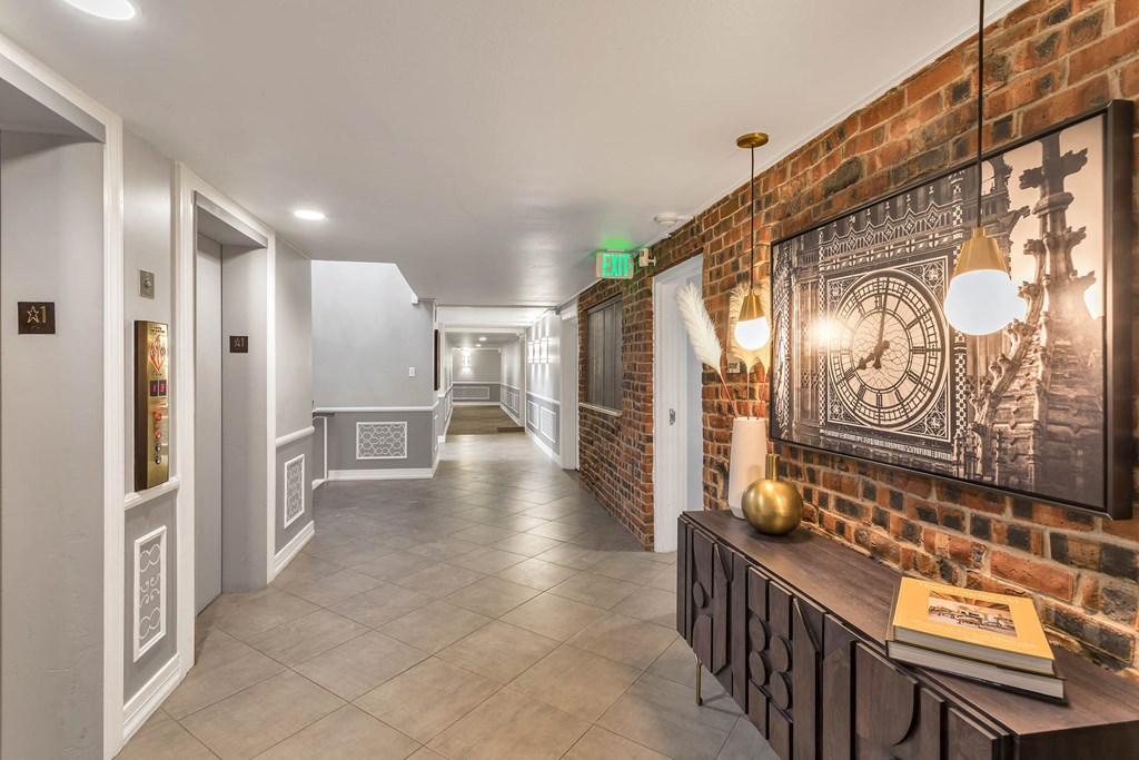 a long hallway with a clock on a brick wall