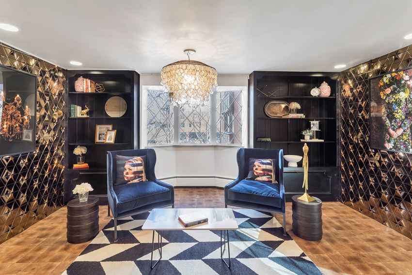 a living room with two blue chairs and a chandelier