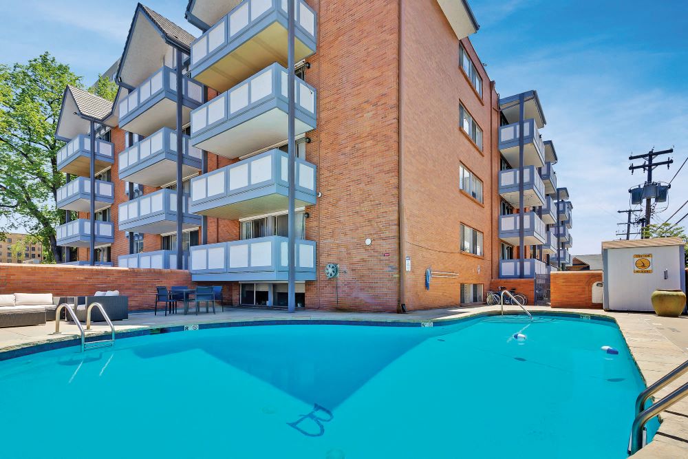 a large swimming pool in front of an apartment building