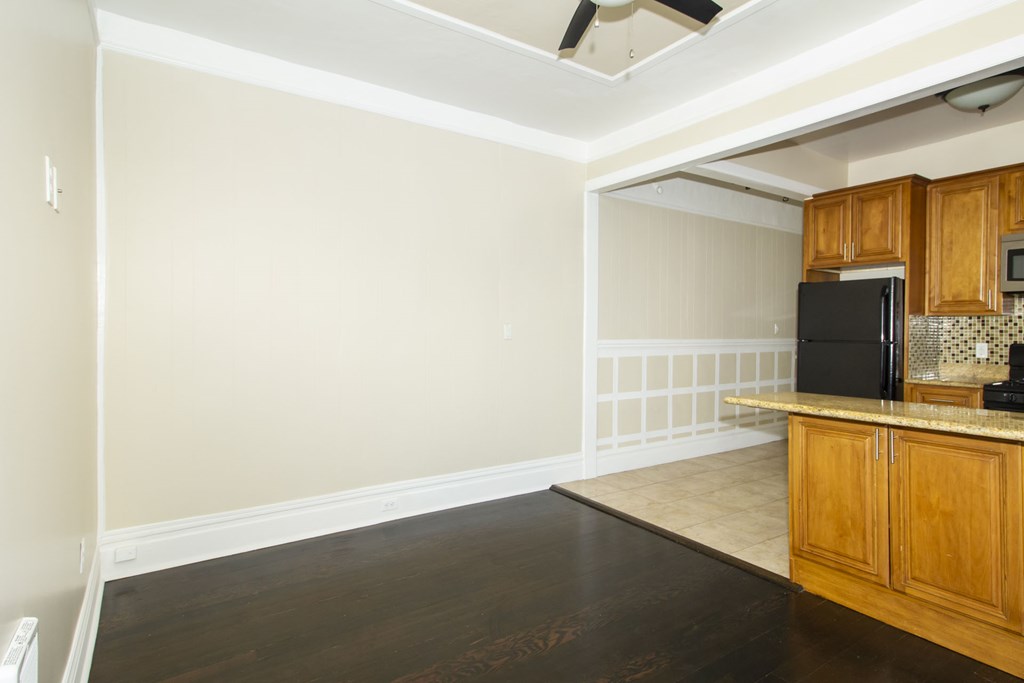 an empty kitchen with wood floors and white walls