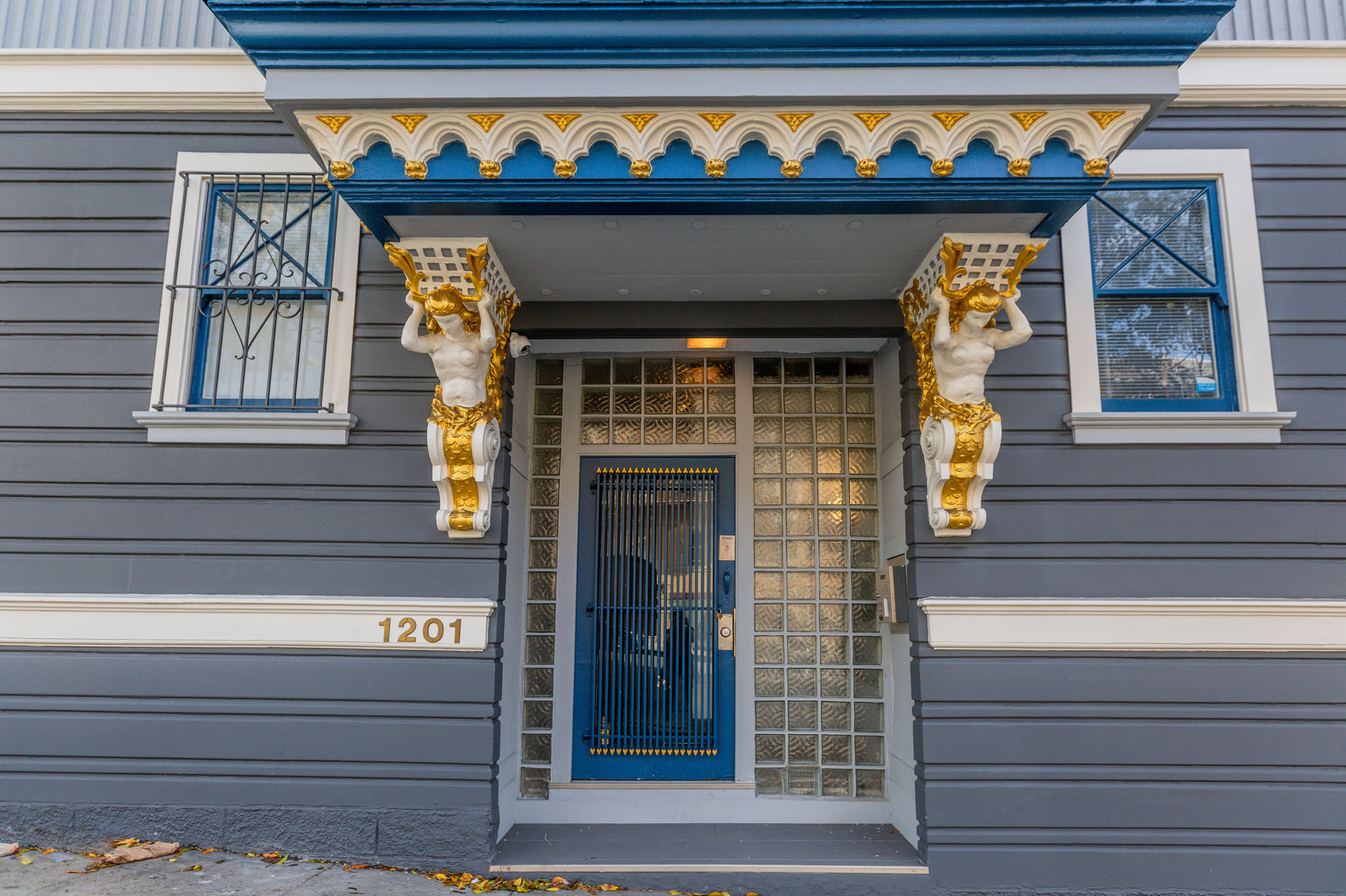 A blue door with a gold number 1201 on the wall.