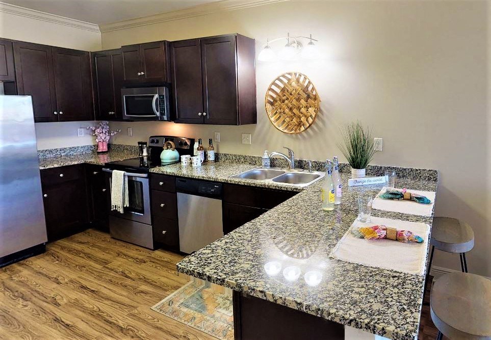 a kitchen with granite counter tops and black cabinets