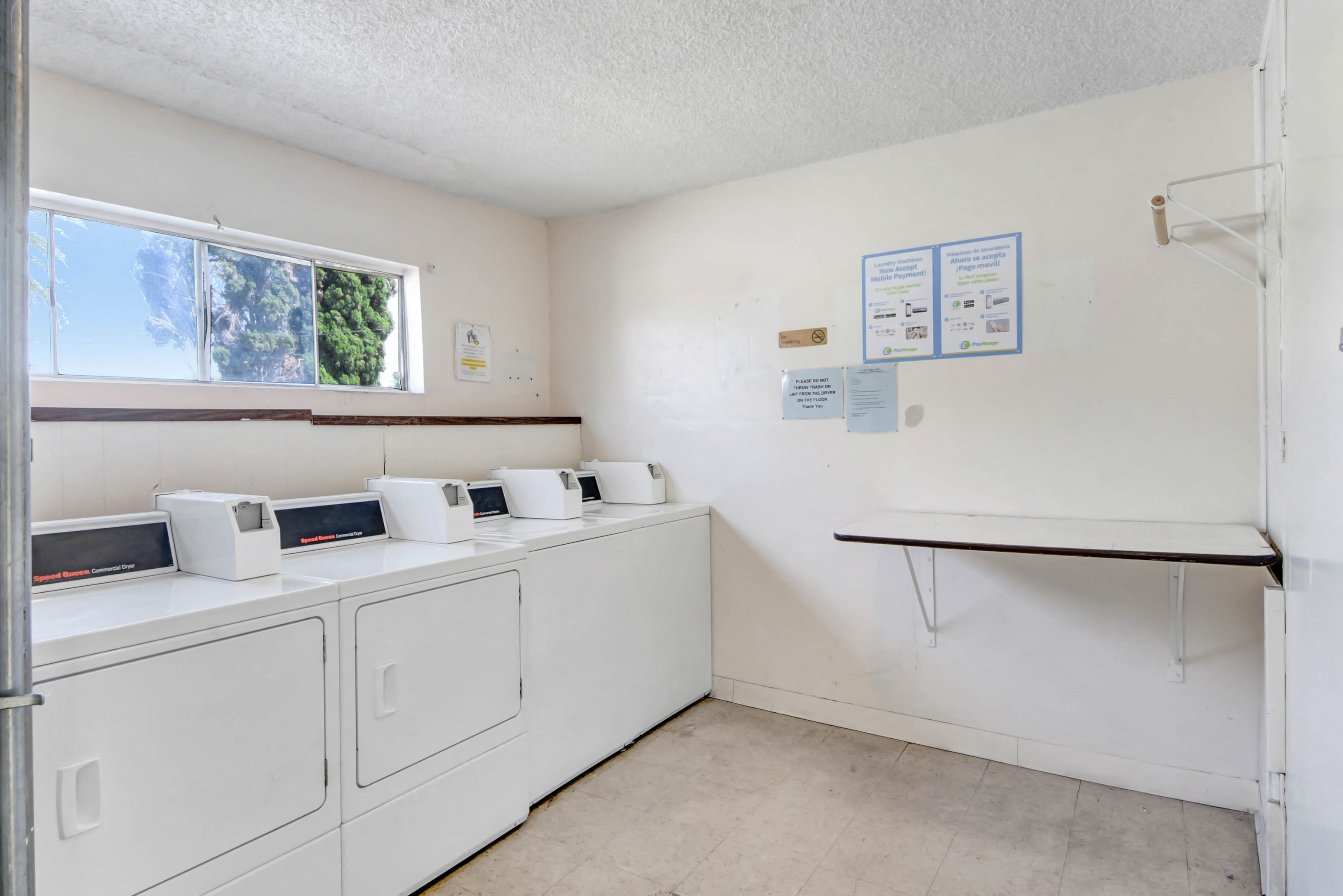 a washer and dryer room with white appliances and a window