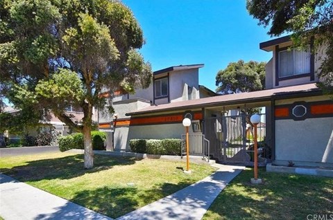 a house with a yard and trees in front of it