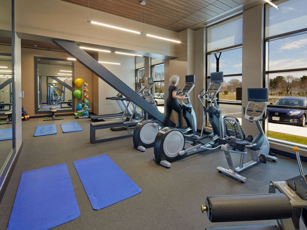 a woman is on a treadmill in a gym with cardio equipment
