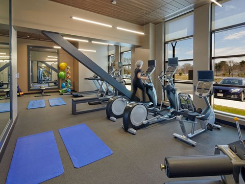 a woman is on a treadmill in a gym with cardio equipment