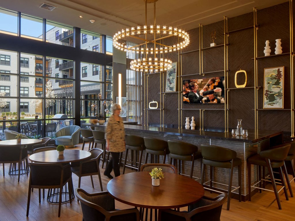 a woman walks through a restaurant with large windows and tables