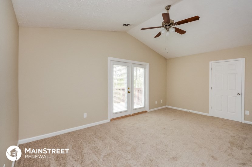 the master bedroom is spacious and clean with a ceiling fan