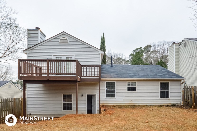 the back of a house with a deck on top of it