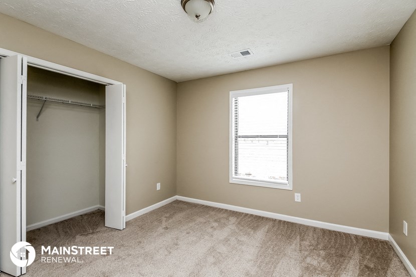 an empty room with a closet and a window