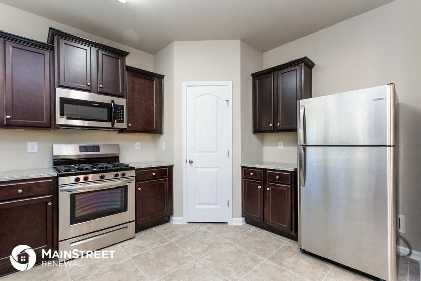 a kitchen with stainless steel appliances and brown cabinets