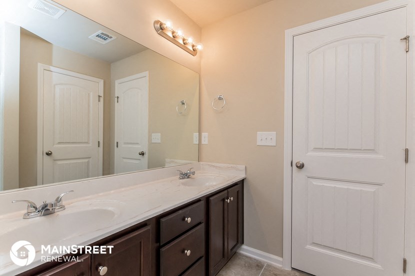 the master bathroom has a large mirror and a large sink