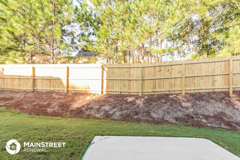 a backyard with a wooden fence and a lawn