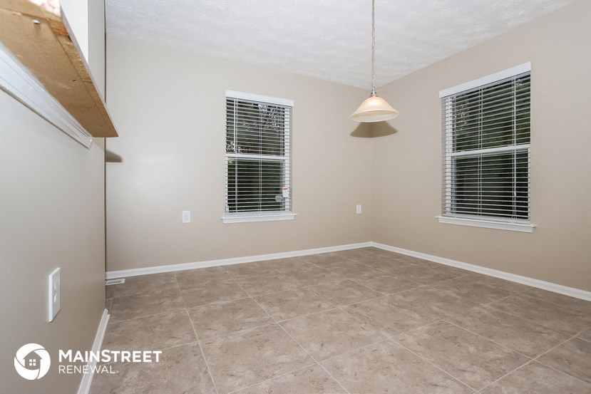 the spacious dining room with tile flooring and two windows