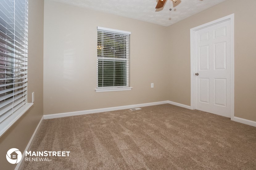 a empty room with a white door and a window