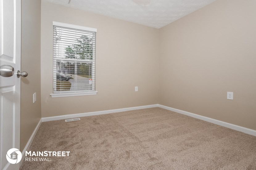 a room with a carpeted floor and a window