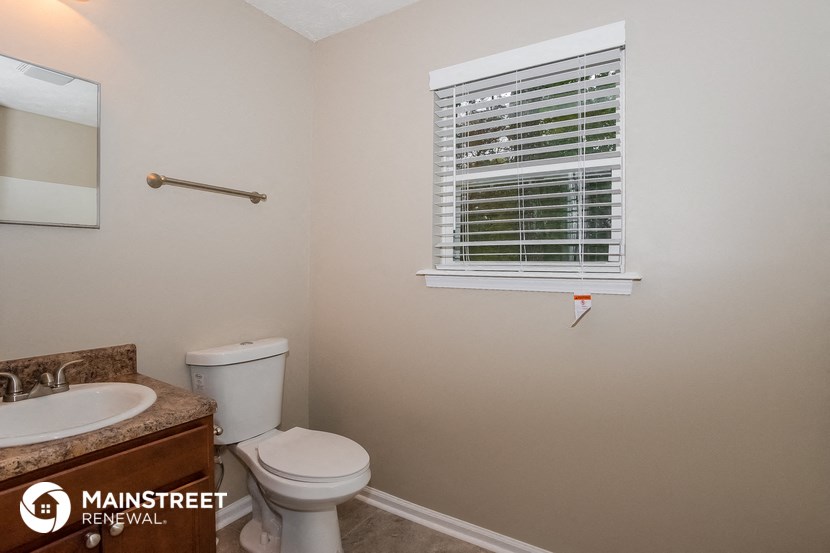 a bathroom with a toilet and a sink and a window