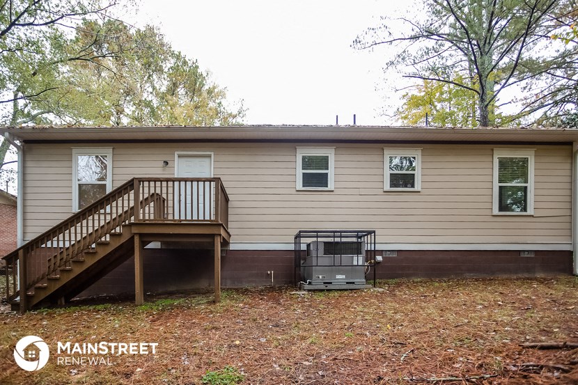 the front of a house with a deck and a staircase