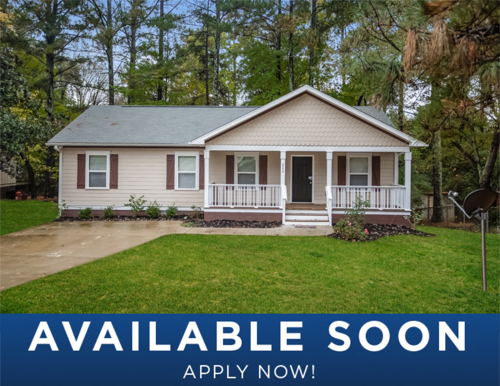 a small tan house with a porch and a green lawn