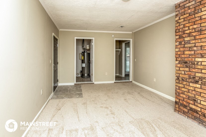 the living room of an empty house with a brick wall