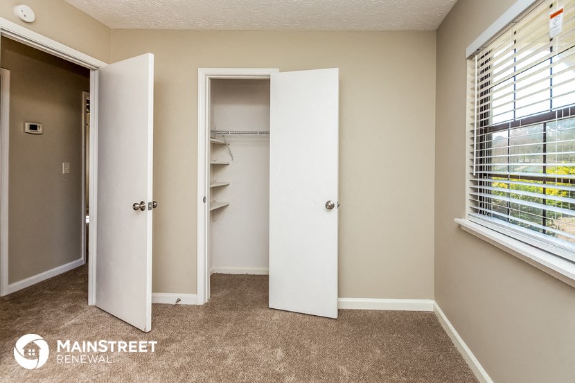 a closet in a room with a window and an open door