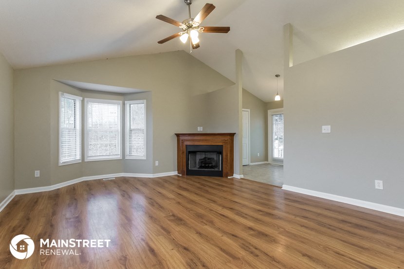 the living room with wood flooring and a fireplace
