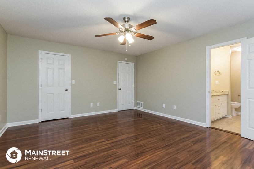 the living room with hardwood flooring and a ceiling fan