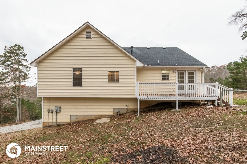 a yellow house with a porch and a white deck