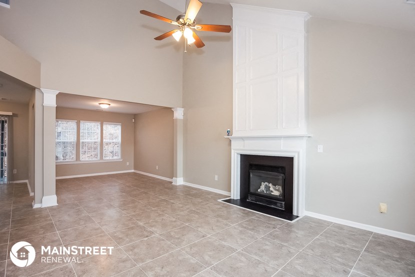 the living room with fireplace and tile flooring