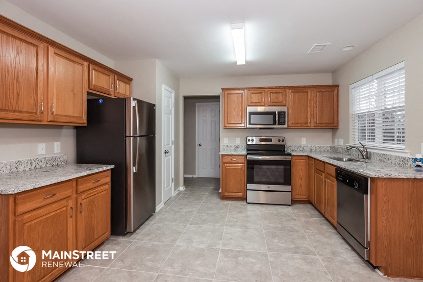 a kitchen with wooden cabinets and stainless steel appliances