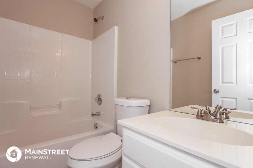 a bathroom with a sink toilet and shower and a mirror
